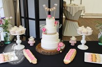 Sweet table vintage pink, bruidstaart met verse bloemen en vintage vlag topper met witte bonbons, cupcakes en macarons