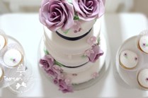 Sweet table paars met grote bruidstaart met handgemaakte suikerbloemen en cupcakes in dezelfde stijl